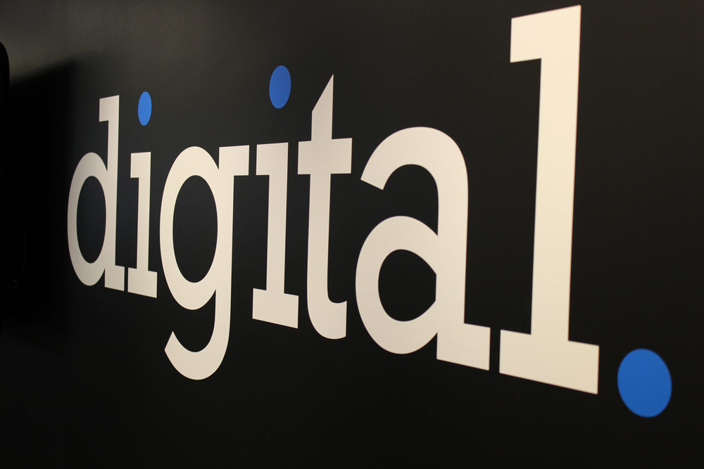 The word digital written in white font with blue punctuation on a black background