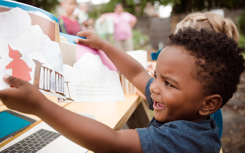 small child holding a book