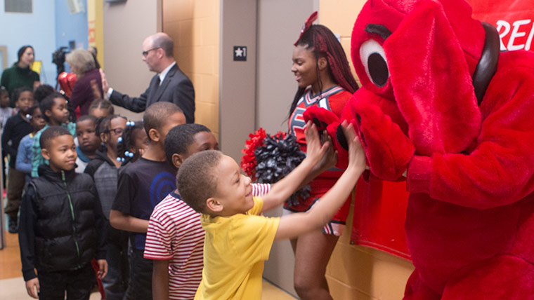 children in line to high-five clifford the big red dog