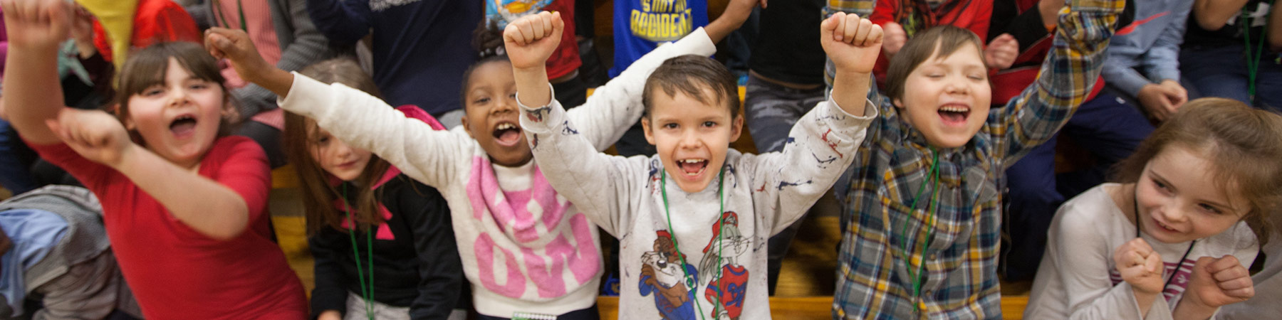 picture of several children cheering while holding their hands up in fists