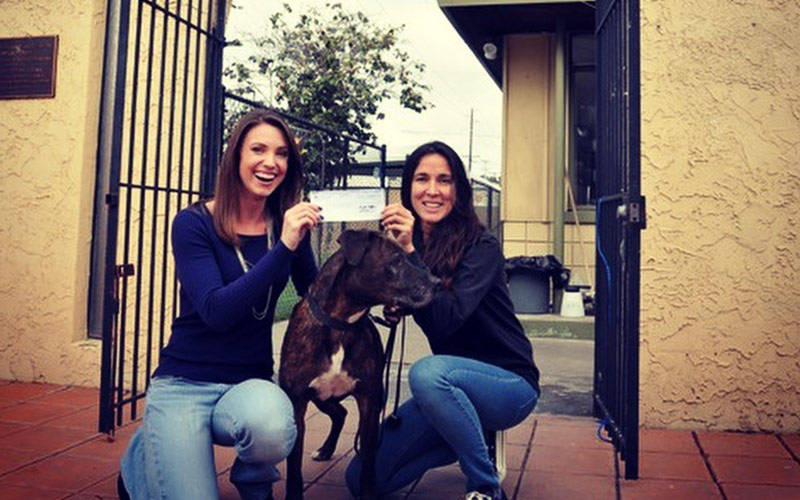 women holding check over dog