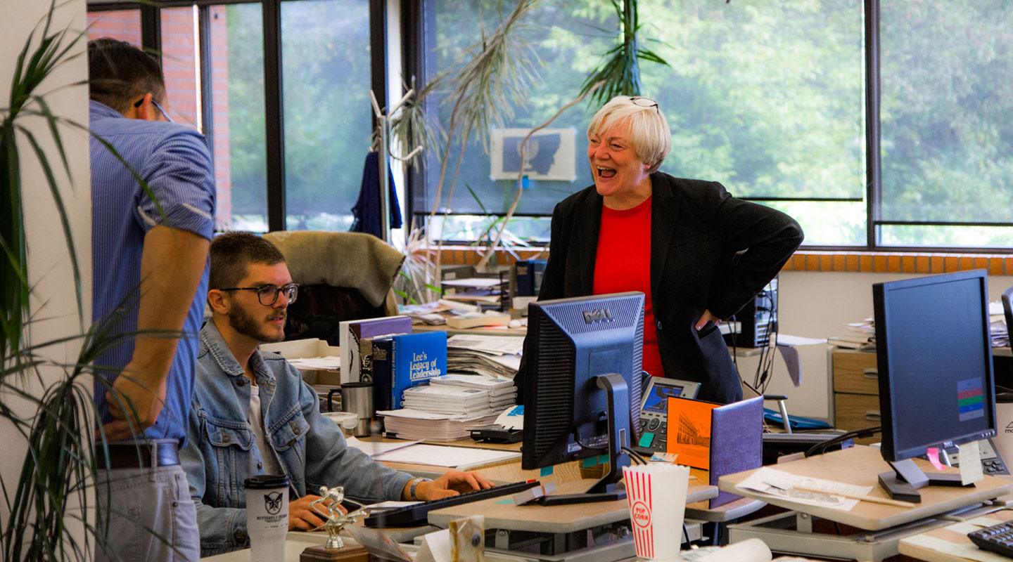workers gather around computer