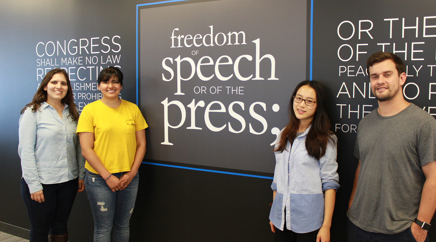 Photo of interns standing in front of a freedom of speech sign