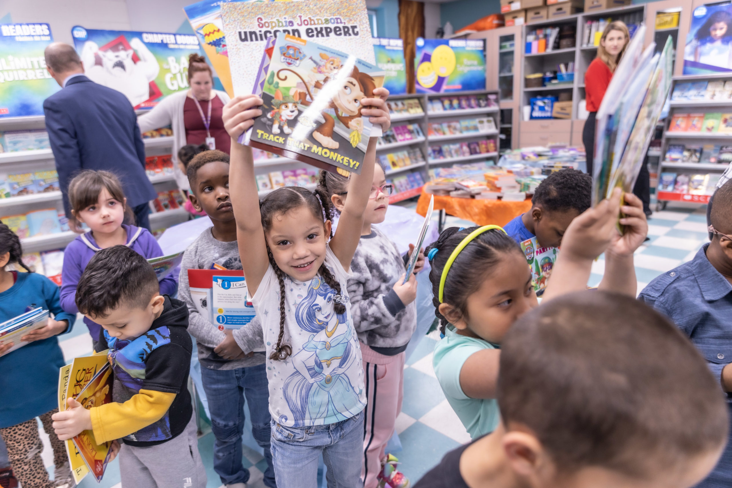 Girl holding up book during a book fair provided by 