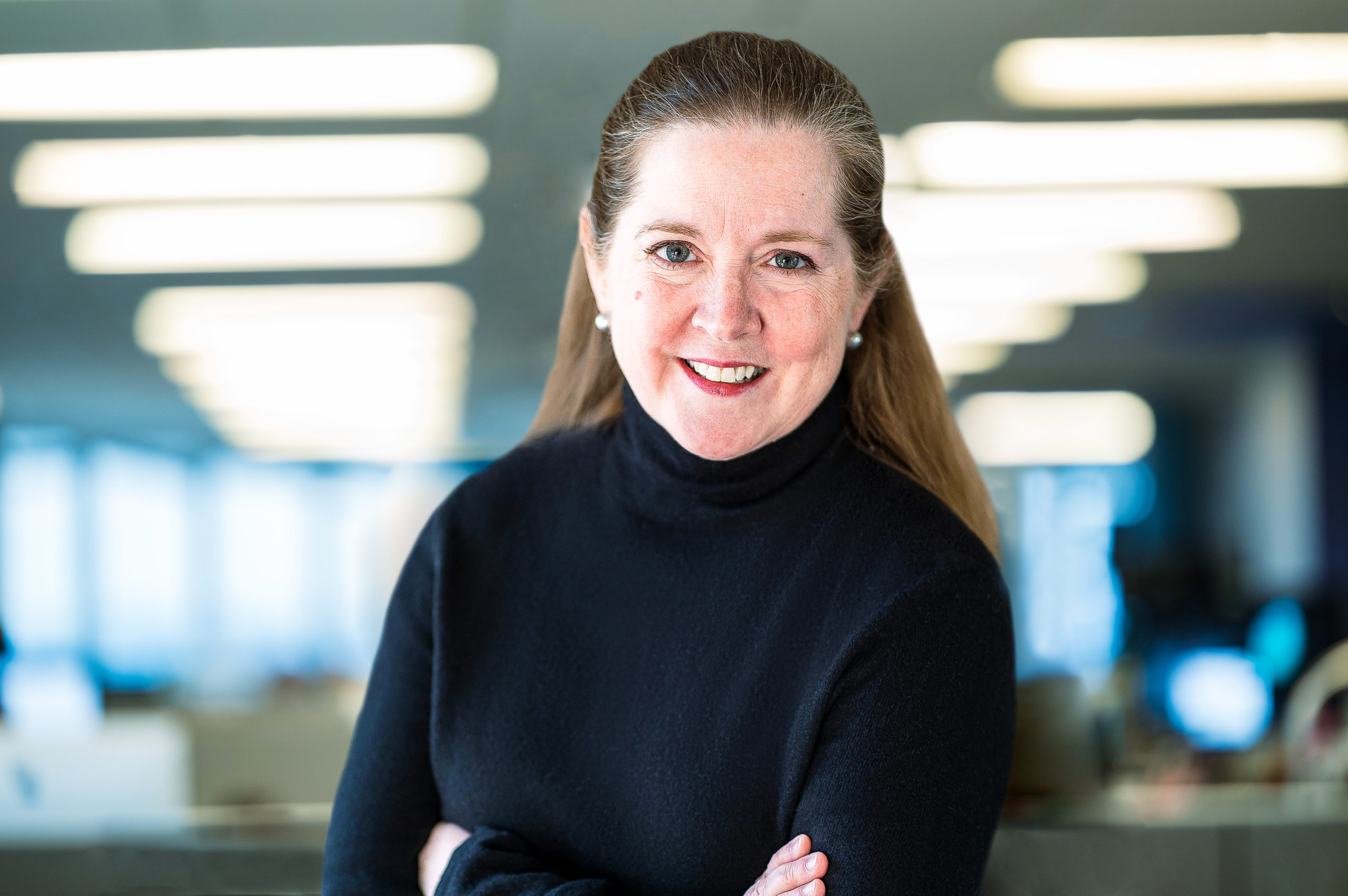 photo of Kate O'Brian Scripps News President in a black turtleneck wearing peal earrings with her arms crossed