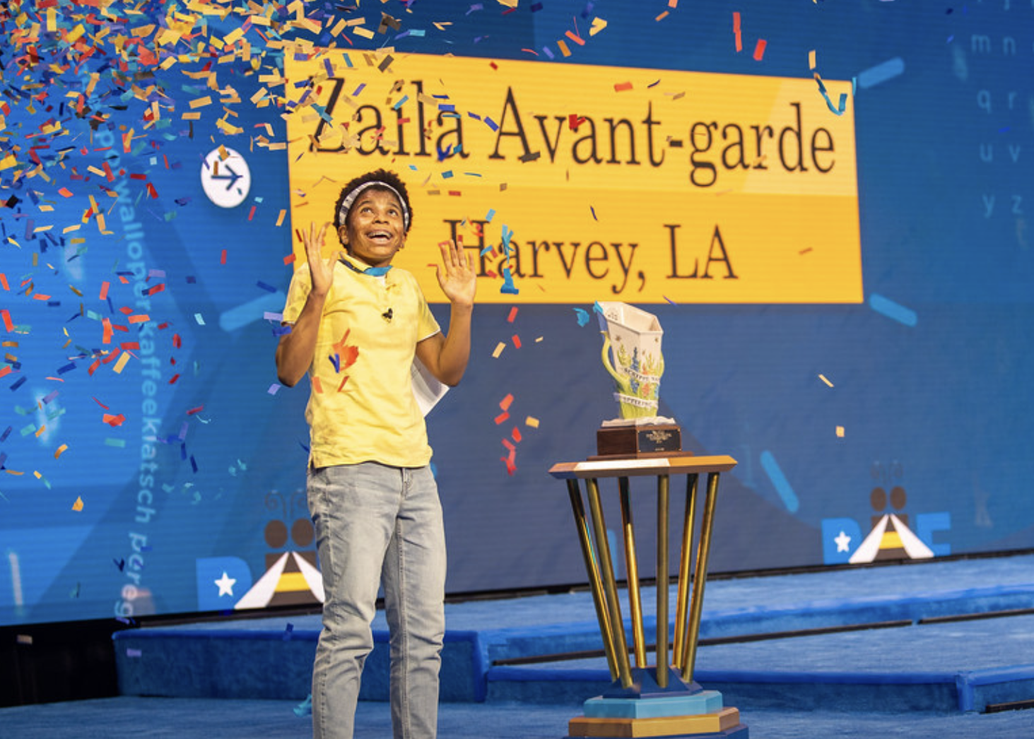 2021 Scripps National Spelling Bee champion Zaila Avant-garde standing onstage as confetti falls from the ceiling following her correct spelling of 