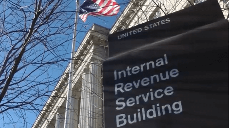Photo of the United States Internal Revenue Service Building with an American flag on a flag pole in front of it