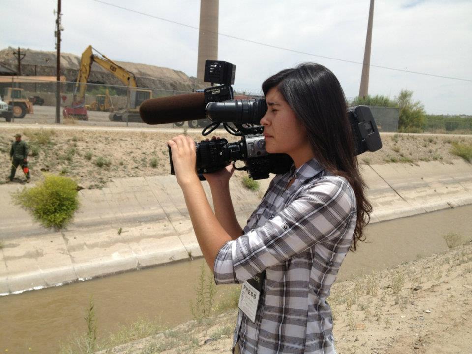 photo of a woman holding a video camera on her shoulder