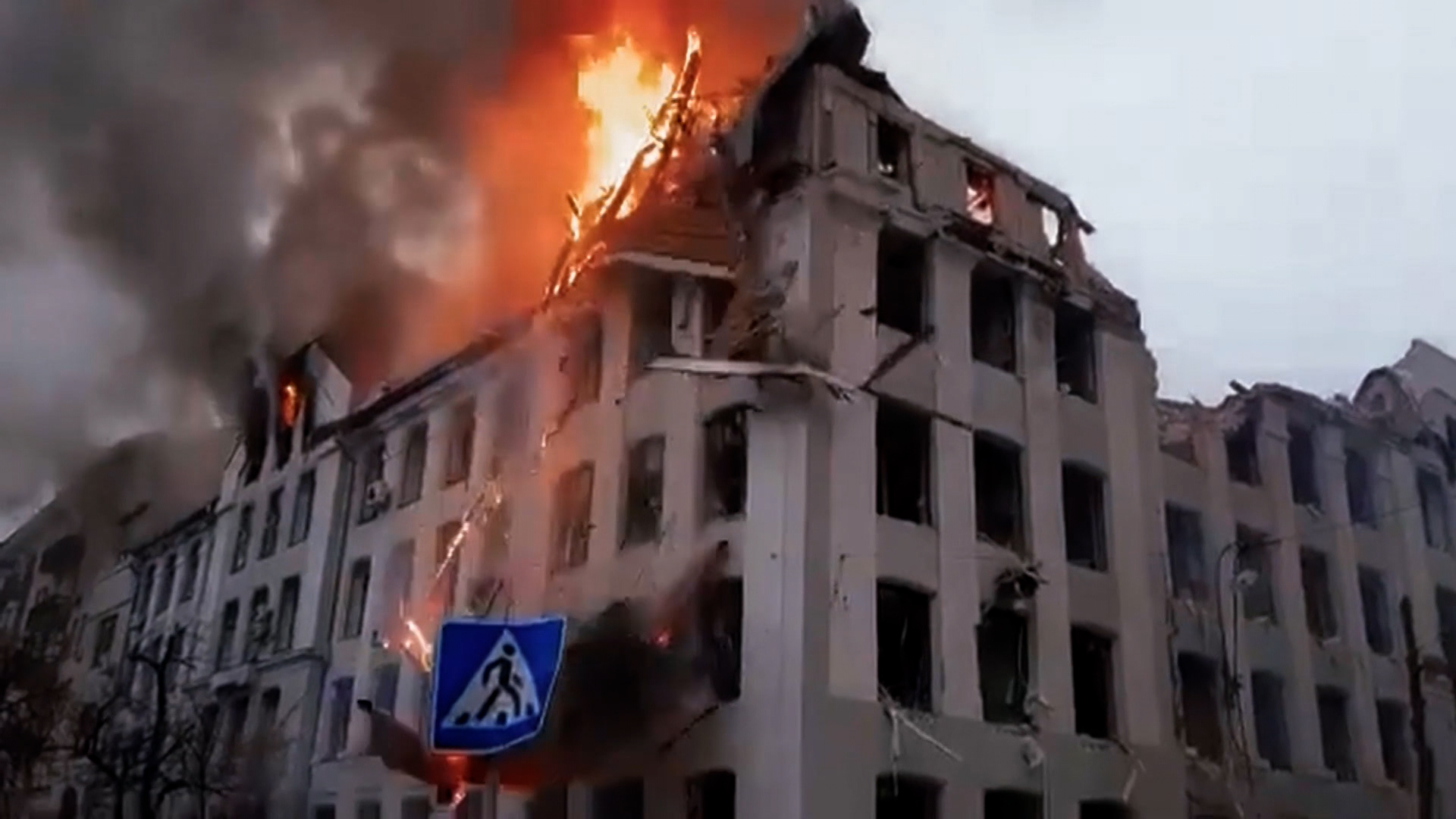 A building in Ukraine has been struck with artillery and the roof has been set on fire.