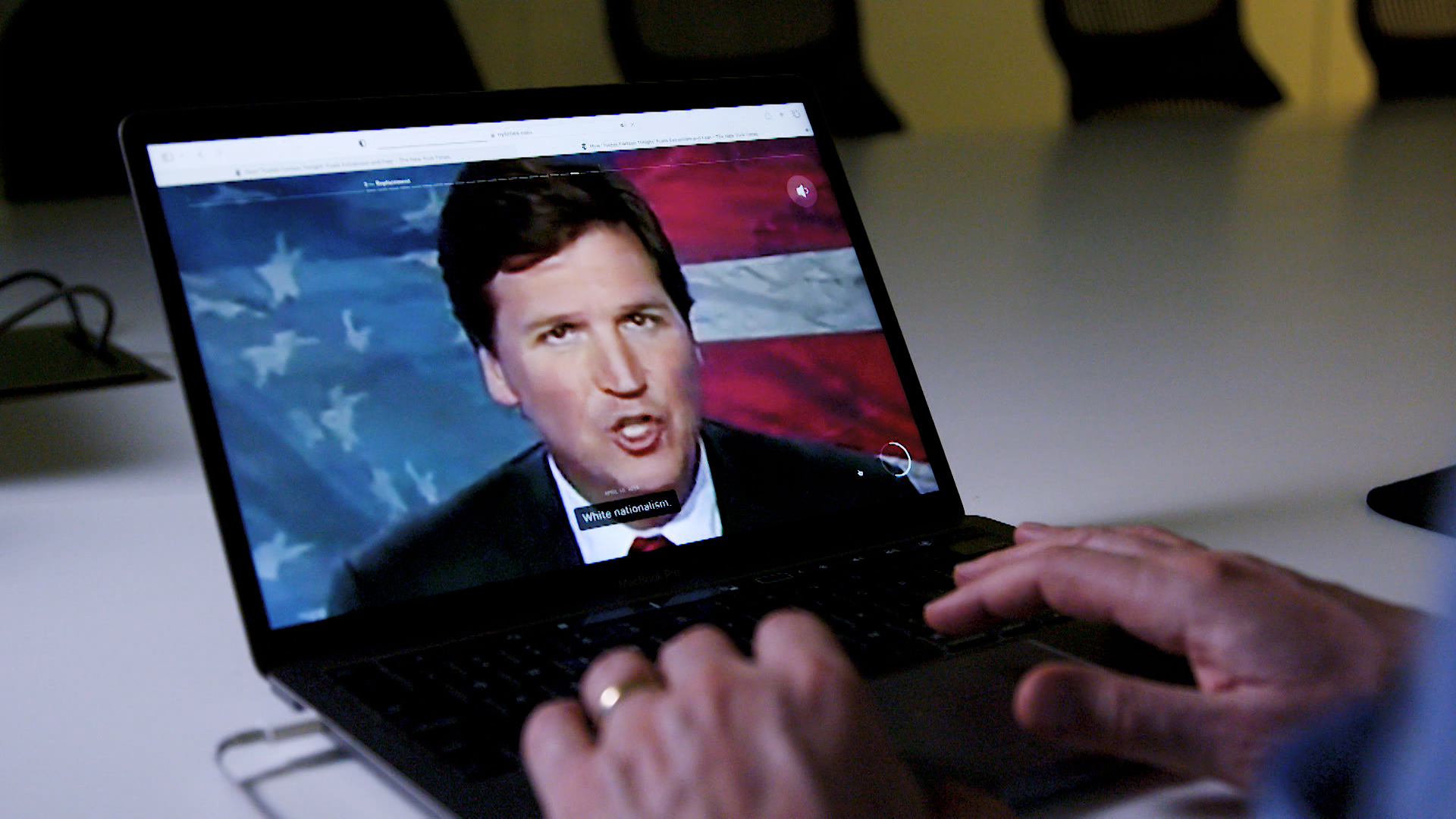 Someone is watching Tucker Carlson's program on a laptop.